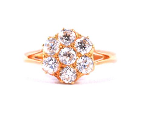 A diamond cluster ring, the seven old brilliant cut stones claw set as a circular floral design in an all yellow metal mount 