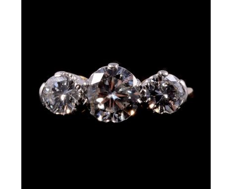 A diamond three stone ring, the brilliant cut stones claw set in 18 carat yellow gold and platinum three stone mount ring siz