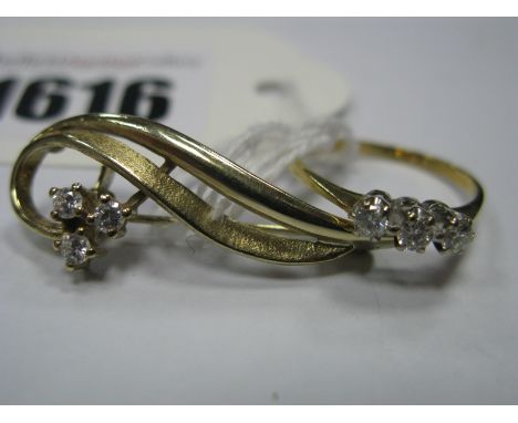 A 9ct Gold Brooch, of openwork design with claw set highlights; an 18ct gold three stone diamond ring, claw set throughout, b