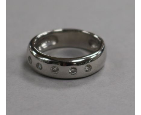 A modern 18ct white gold and five stone gypsy set diamond ring, size K.