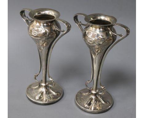 A pair of Edwardian Art Nouveau silver presentation bud vases, the bowls of bulbous form, embossed with poppies, on long tape