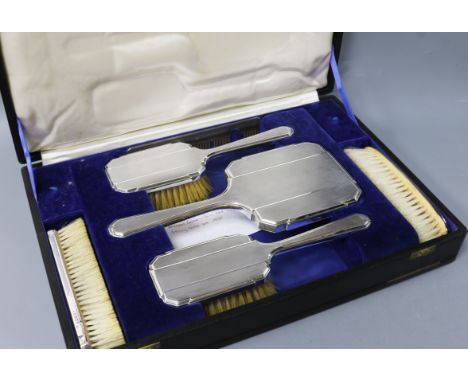 A cased George V Art Deco engine turned silver six piece dressing table set, William Comyns & Sons Ltd, London, 1935.