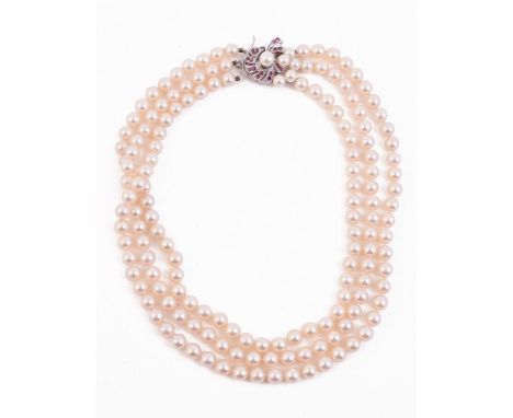 
	
		A THREE STRAND CULTURED PEARL NECKLACE 
		The three rows of uniform cultured pearls on a knotted strand, to a cultured p