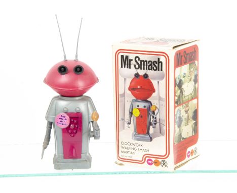 A Marx Toys Plastic Clockwork Mr Smash Walking Martian, grey body, pink head and chest panel, silver arms and removable anten