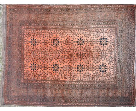 A large early 20th Century Persian Islamic floor carpet rug having a red ground with central panel having geometric decoratio