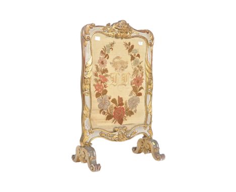 A 19th Century gilt brass tapestry fire screen. Central embroidered panel set within gilt brass frame raised on shaped leg su