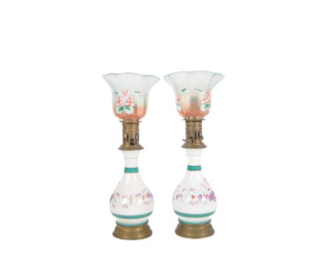 A pair of 19th Century porcelain table oil lamps. Tall glass flumes with coloured and painted glass tulip shades raised on wh