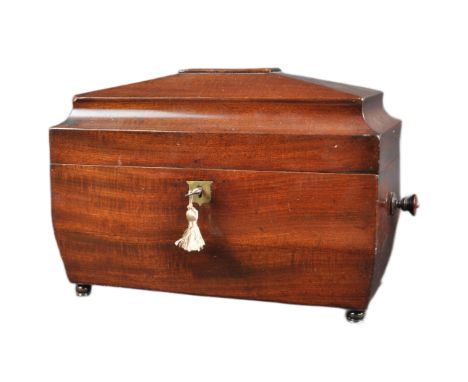 A 19th Century mahogany Regency tea caddy having a sarcophagus form lid with bombe sides and twin handles. The hinged lid ope