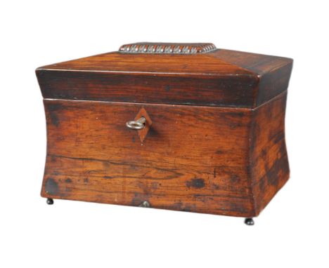 An early 19th Century Regency mahogany tea caddy of sarcophagus form. Beaded decoration to lid with shaped sides. The hinged 
