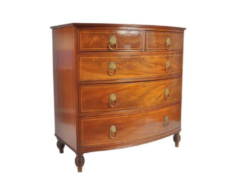 An early 19th Century George III mahogany inlaid bow fronted chest of drawers. The bank of two over three drawers having lion