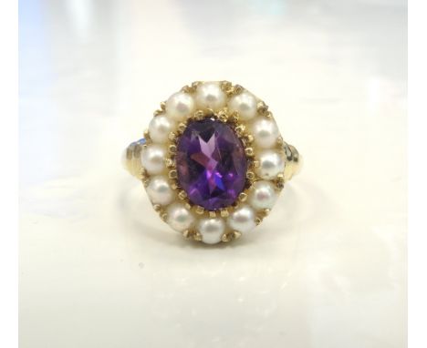 AMETHYST AND PEARL CLUSTER DRESS RINGthe central oval cut amethyst in twelve pearl surround, on nine carat gold shank, ring s