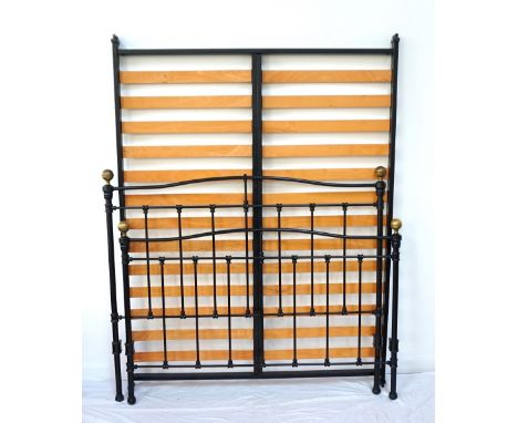 WROUGHT IRON DOUBLE BEDwith a shaped head and foot board, each with circular brass finial globes, 154cm wide 