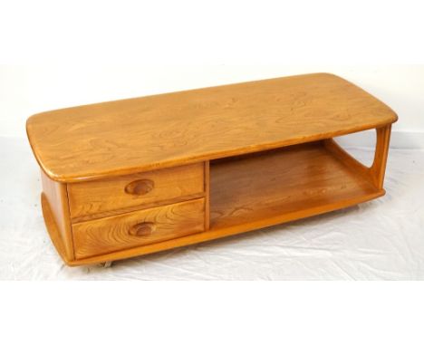 ERCOL OAK OCCASIONAL TABLEwith an oblong top above two short drawers and an open shelf, standing on castors, 125cm wide 