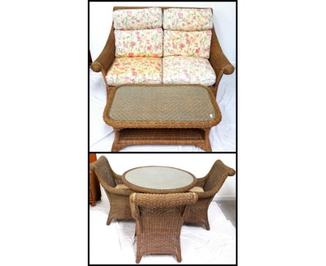 RATTAN CANE CONSERVATORY SUITEcomprising a two seat sofa with floral cushions, four armchairs with seat cushions, a circular 