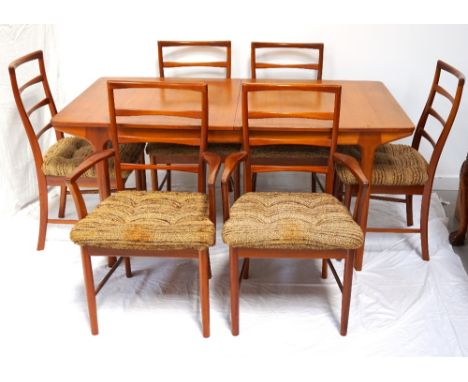 1970's TEAK EXTENDING DINING TABLEwith fold out leaf's below the pull apart top, standing on turned tapering supports, togeth