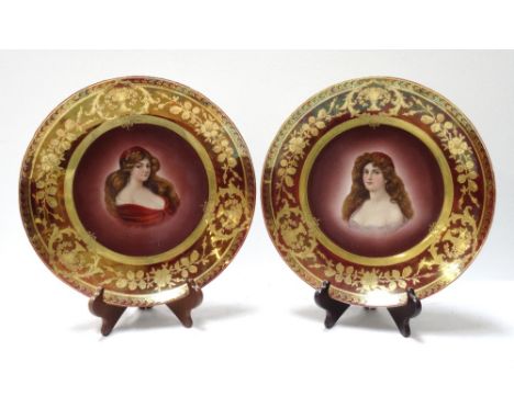 TWO CONTINENTAL PORCELAIN PORTRAIT PLATESeach with a claret ground and a gilt border with floral and urn motifs around a fema