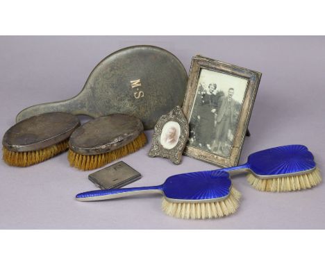 A pair of silver-backed clothes brushes; two silver photograph frames; a silver engine-turned compact; &amp; three dressing t