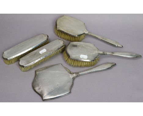 A George V engine-turned silver-backed five-piece dressing table set Birmingham 1934.
