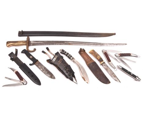 A Chassepot bayonet, in its scabbard; 2 sheath knives, a small kukri, 3 clasp knives and a folding comb. QGC to GC £30-35 