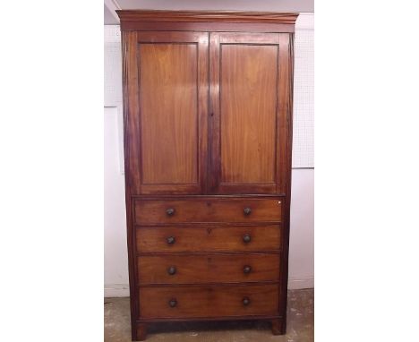 A 19th century tall mahogany linen press with two doors enclosing slide out trays, all over four drawers and raised on bracke