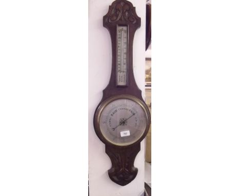 An oak cased barometer/thermometer with carved decoration