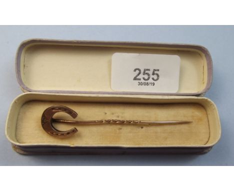 A 9 carat gold stick pin shaped as a horseshoe