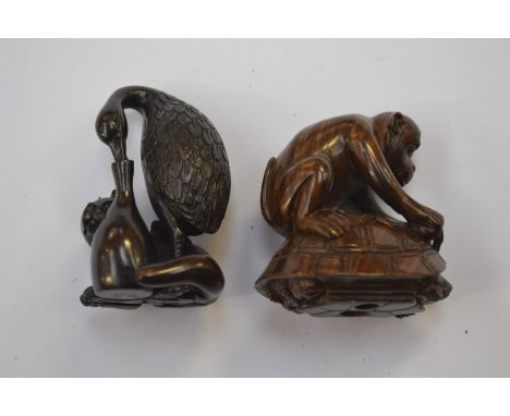 A&nbsp; Japanese dark wood Netsuke which depicts a large bird and a small dog, the bird has its beak in a bottle, excellent c