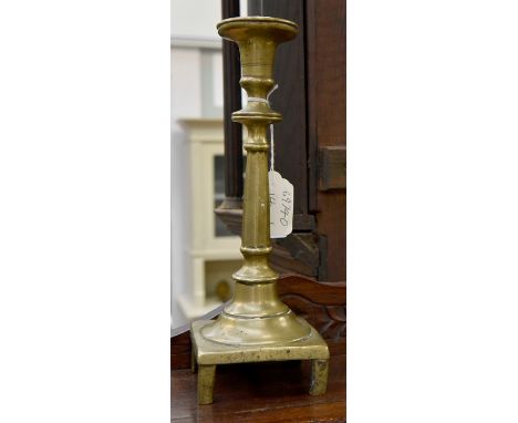 A late 17th/early 18th Century brass candlestick on stile feet