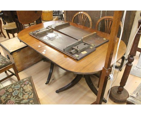 An extending dining table in the Georgian style, on tripod sabre legs with claw metal feet and brass castors.&nbsp;