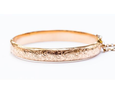 A 9ct rose gold bangle, hinged, scroll and foliate engraved decoration, internal diameter approx. 60mm, weight approx. 13gms 