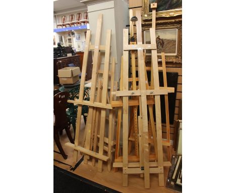 Six artists' wooden easels, one having a mounted light.&nbsp;