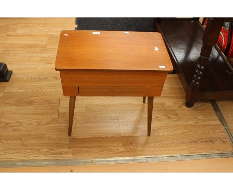 A light wood sewing box on legs, lined with yellow fabric.