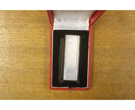A Cartier white metal lighter, ribbed, boxed