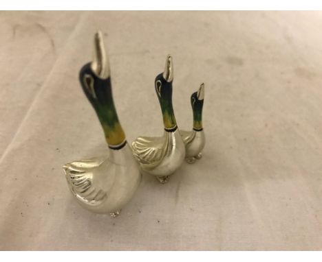 A trio of silver and enamel runner ducks