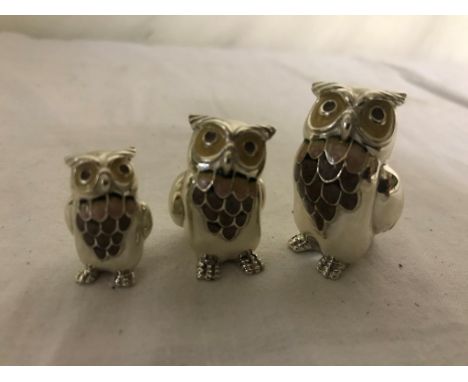 A trio of silver and enamel owls