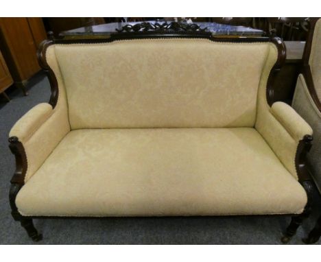 An Edwardian mahogany framed two seater sofa with carved ribbon and swag top rail