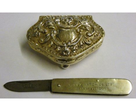 A silver cartouche shape trinket box Birmingham 1903 with embossed decoration and a Rolex penknife