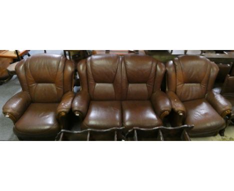 A mahogany three piece brown leather suite, comprising a two seat sofa and two armchairs