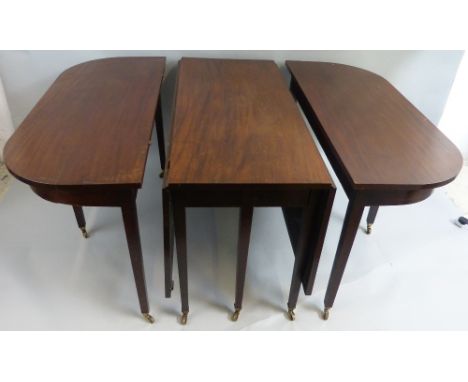 A Georgian mahogany three-section extending dining table, comprising drop-leaf centre section with double gate-leg action to 