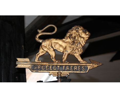 A Peugeot Freres cast metal sign,double-sided gilt painted metal lion standing on a rotating arrow lettered 'Peugeot Freres' 