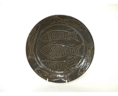 An Abuja studio pottery plate with incised fish detail. Seal to side mostly filled with glaze. Christies label to base. 26.5c