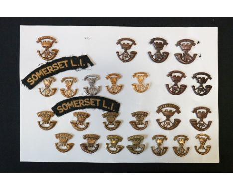 A Collection Of Twenty Six Somerset Light Infantry Cap Badges, Collar Badges And Cloth Shoulder Titles. 