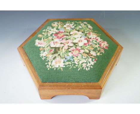 A vintage hexagonal footstool with floral tapestry upholstery  