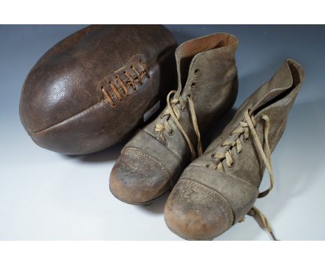 A vintage leather rugby ball and boots