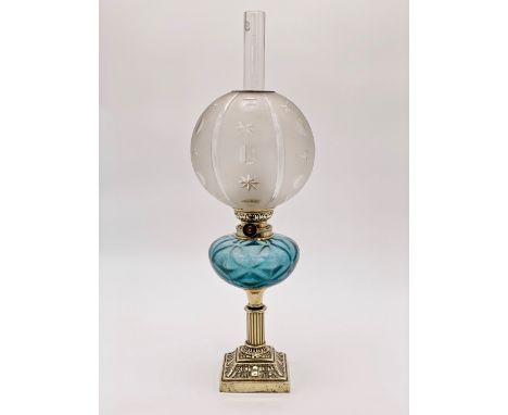 A Victorian brass columnar oil lamp having a blue glass reservoir and frosted and cut glass globe