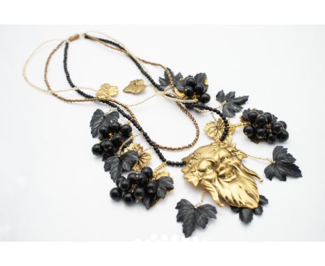 A vintage gilt-metal and Lucite necklace incorporating the mask of Bacchus and fruiting vines, suspended from three beaded ne