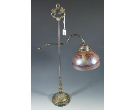 A contemporary brass lamp with glass shade