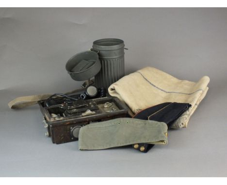 A group of militaria comprising a German Field telephone in bakelite case, Third Reich cloth grain sack, German Gask Mask can