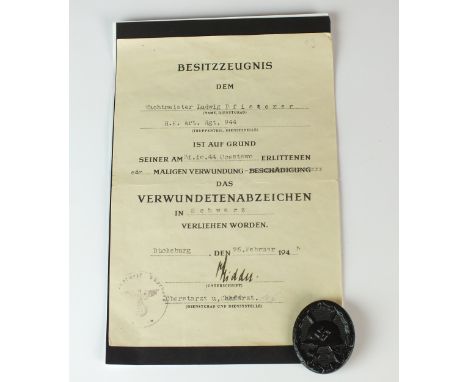 A Second World War German black wound badge with a certificate of the award named to Wachtmeister Ludwig Pfisterer of H.K. Ar