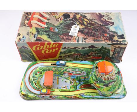 A Technofix cable car tinplate toy with 2 cable cars that move on a cable up and down, also 2 ti cars go around a treack as w